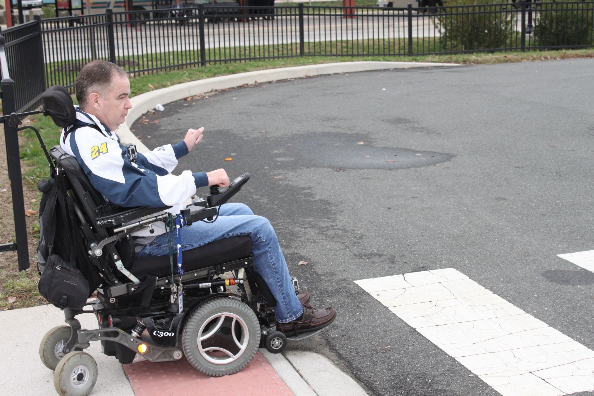 An image of a man using a wheelchair to cross the street, demonstrating the importance of ADA accessibility.