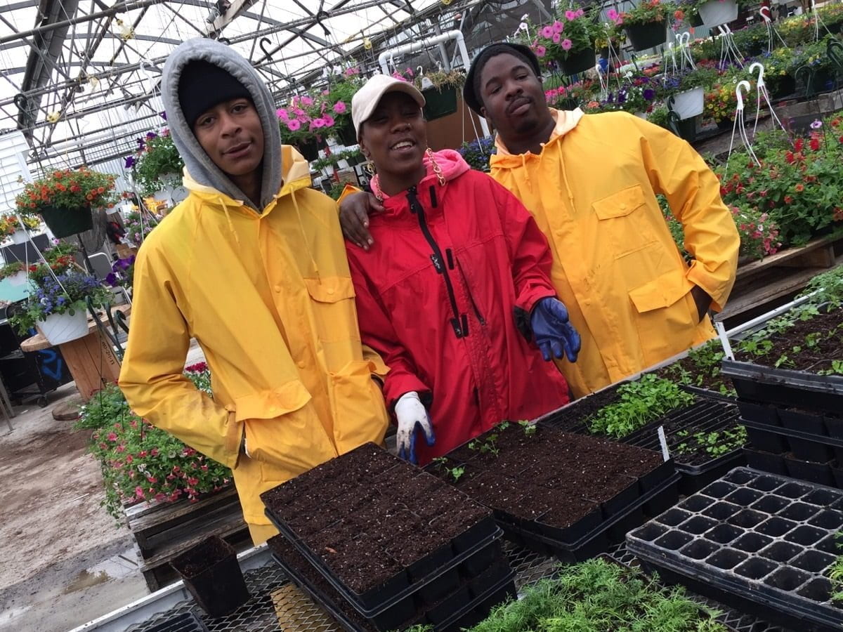 Image of participants in the Bright Spot Farms program standing in the greenhouse.